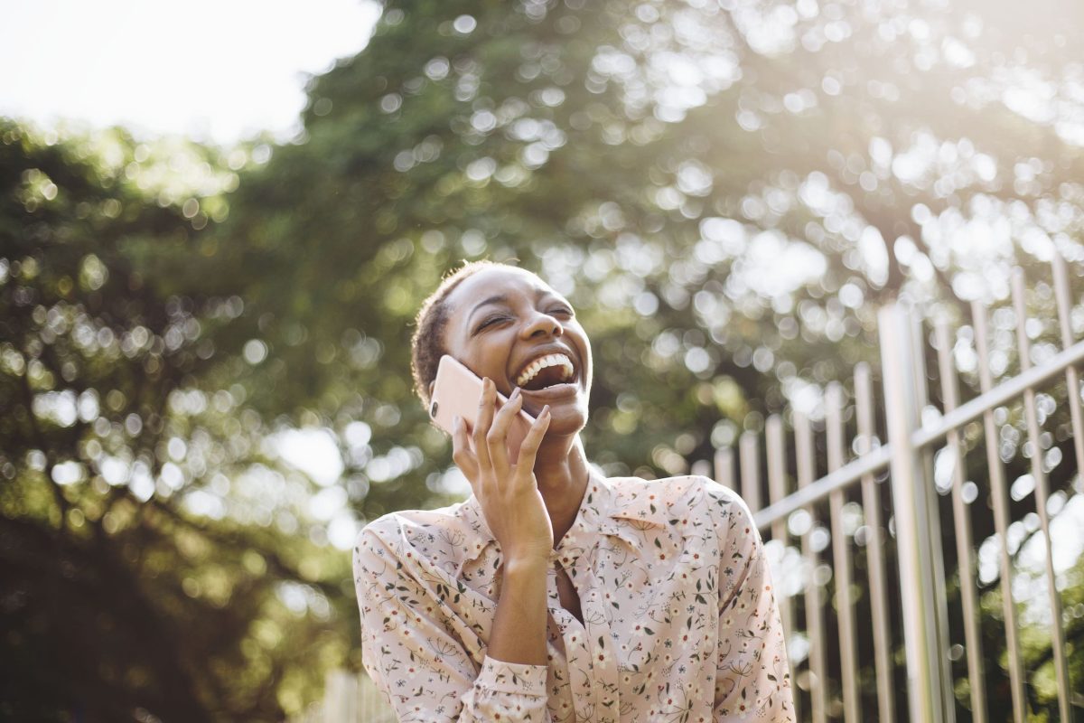 Mujer con fondo de naturaleza al aire libre platicando por celular